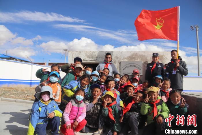 图为师生和民警在温室门口合影。　罗峰 摄