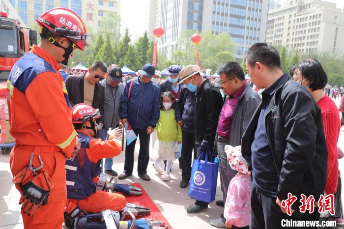 图为消防员向群众讲解消防装备器材。　青海消防供图