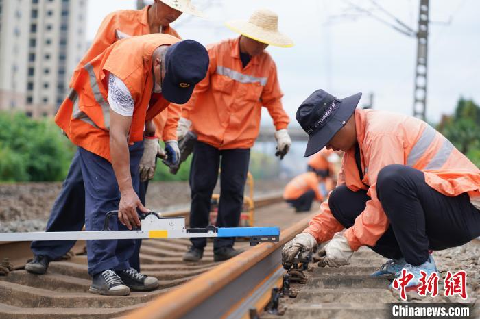 图为施工完毕后，作业人员复核线路轨距、水平。　黄钟滨 摄