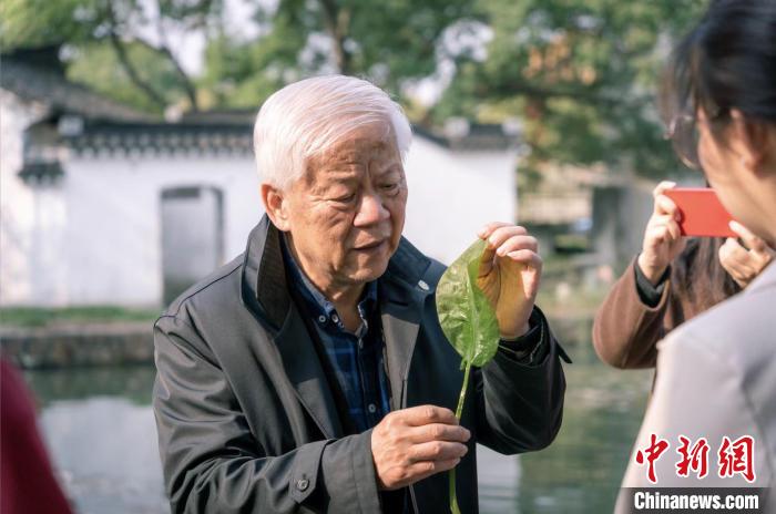 孔海南为青年学子介绍“水质风向标”海菜花。　上海交大供图