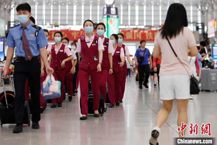 列车乘务员在铁路上海虹桥站候车大厅内行走。　殷立勤 摄