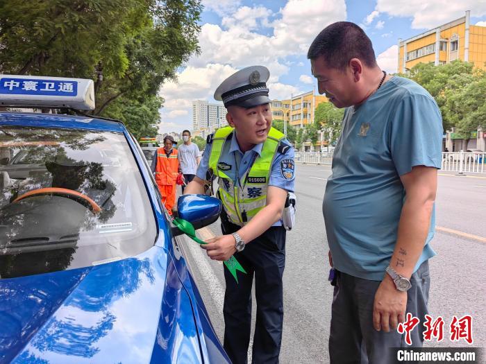 图为呼和浩特交警为送考车辆系上绿丝带。　张林虎 摄