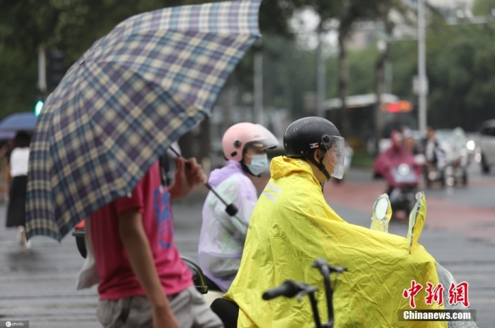 7月21日清晨，北京市民骑行在雨中。图/ICphoto