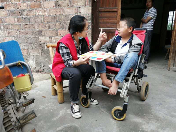 叶年华的儿子叶思同与送教下乡老师玩拼图游戏