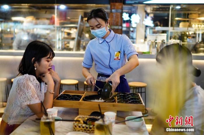7月29日晚，云南昆明，一餐饮店服务员正在为顾客服务。 <a target='_blank' href='http://www.chinanews.com/'>中新社</a>记者 康平 摄