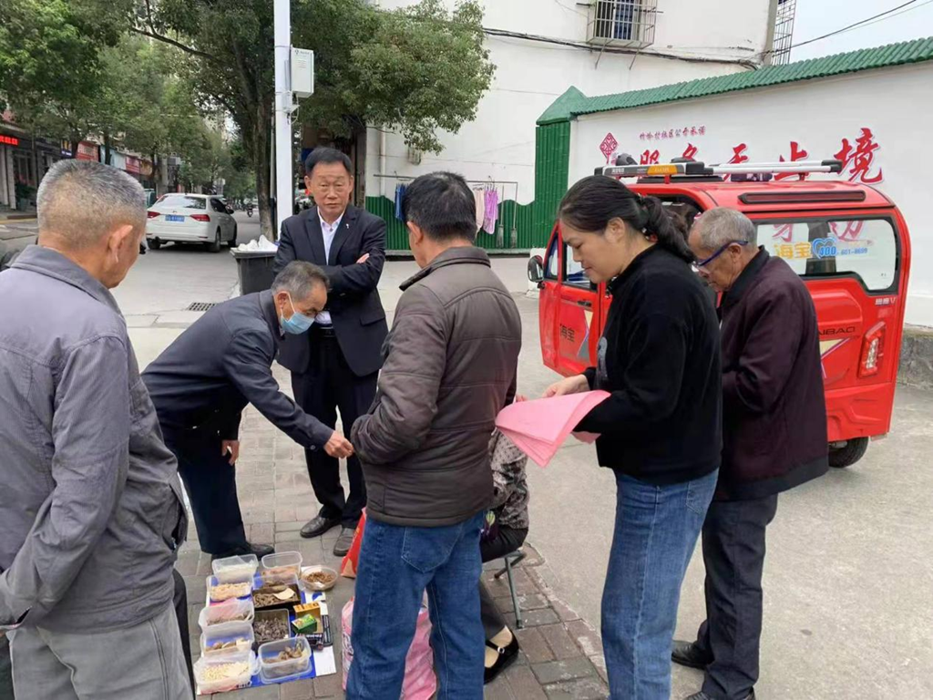 武寧縣豫寧街道竹嶺村社區幹部走上街頭髮放禁毒宣傳單