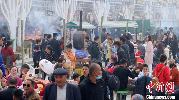 新疆库尔勒市梨花节吸引全国各地商户来此打卡，摆摊售货。　王小军 摄