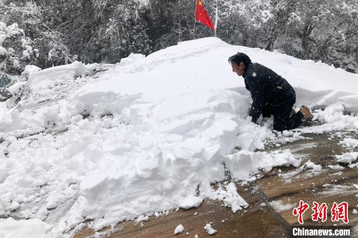 资料图为2021年12月，戍边执勤人员清理德玛龙6号执勤点屋顶的大雪。　拉郊边境派出所 供图