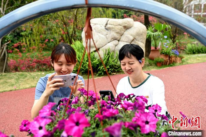 彭素萍(右)与舍友在闽南师范大学校园内观赏花卉。　张金川 摄