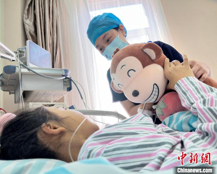 在儿科重症医学科(PICU)，吴函书与小患者交流，鼓励她战胜病魔。　郭佳 摄