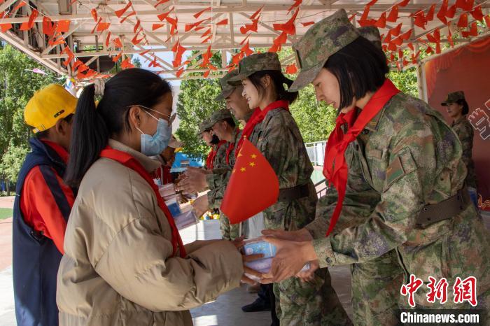 图为女兵们为孩子们送上节日礼物。　张赢 摄