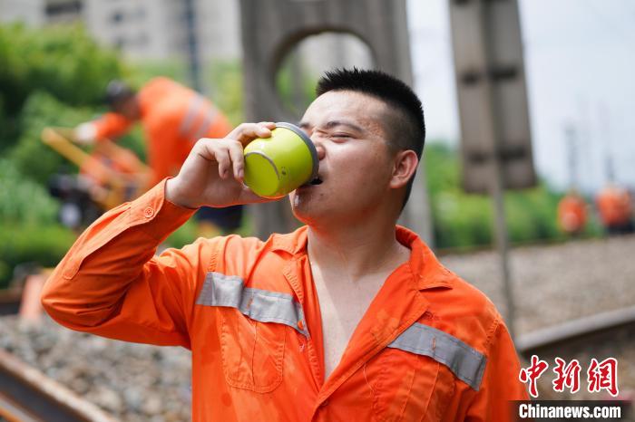 图为高温下铁路工人饮水消暑。　黄钟滨 摄