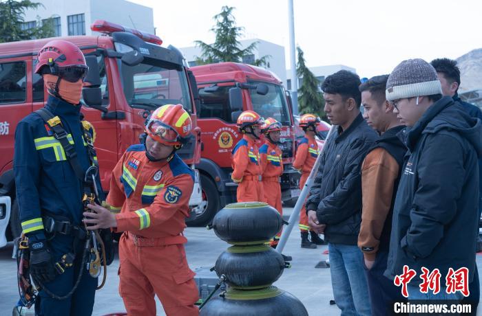 图为消防员为学生讲解消防器材。　贡嘎来松 摄