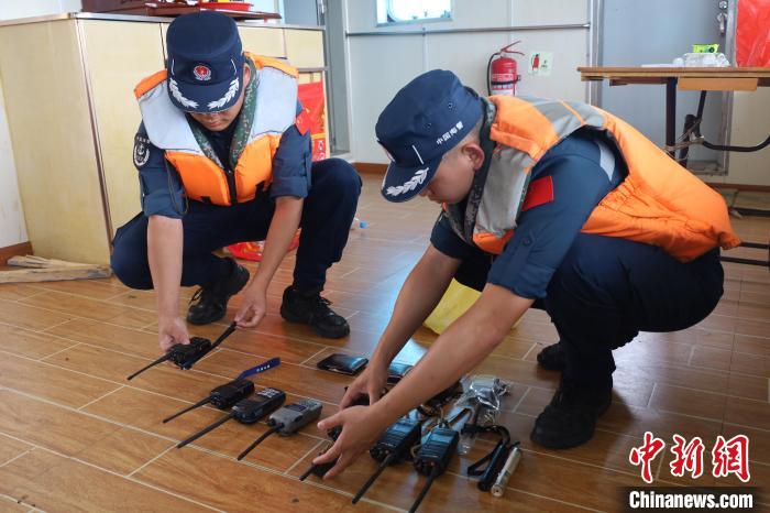 图为海警执法员正在对涉案物品进行点验。　王晨奕 摄