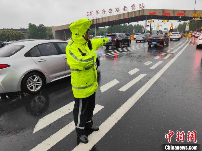 上海市公安局崇明分局民警在G40陈家镇收费口雨中指挥车辆。　上海市公安局供图