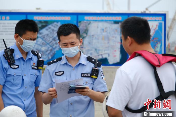 平潭边检站移民管理警察对船员证件进行查验。　李宗艺 摄