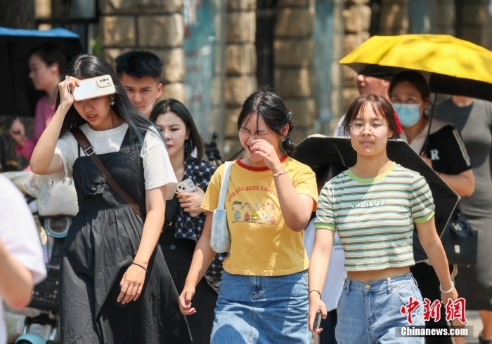 6月23日，北京高温天气持续，市民冒着高温出行。当日，北京市气象台升级发布高温红色预警信号。中新社记者 贾天勇 摄