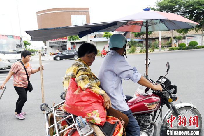 “担担军”搭乘摩托车到距离玉林火车站更远的地方去摆卖。　蒋雪林 摄