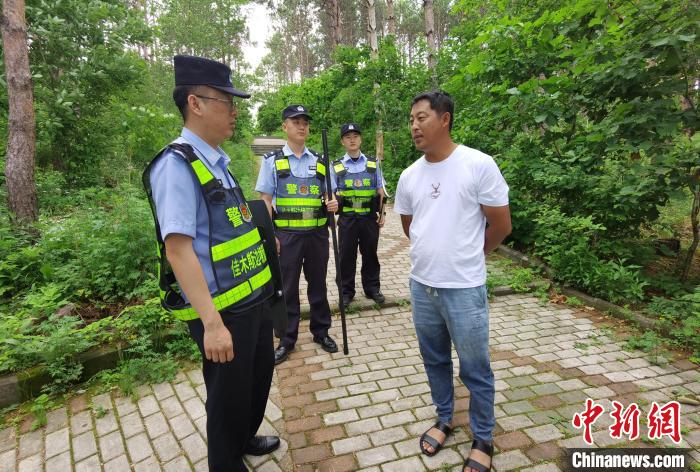 民警劝导附近居民远离熊出没地带。　佳木斯边境管理支队供图