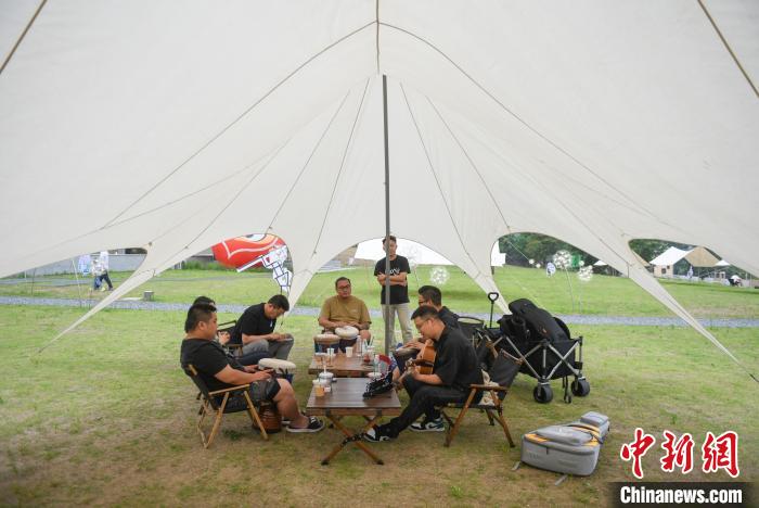 多名年轻人在安吉余村的户外帐篷下休闲。　王刚 摄