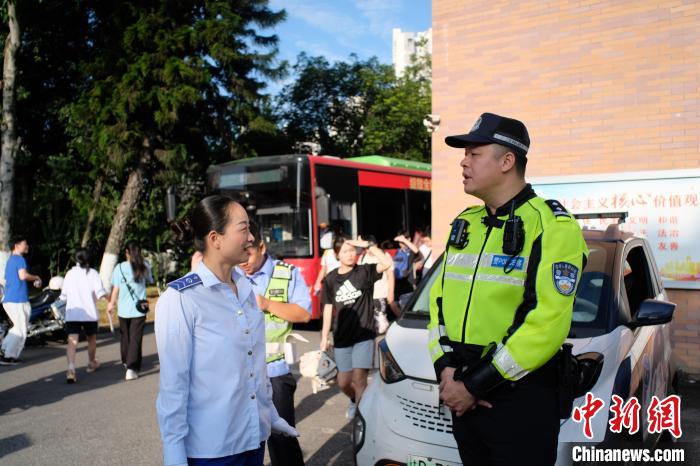 图为顾芳(左)正在与开路交警沟通路线。　刘俊聪 摄