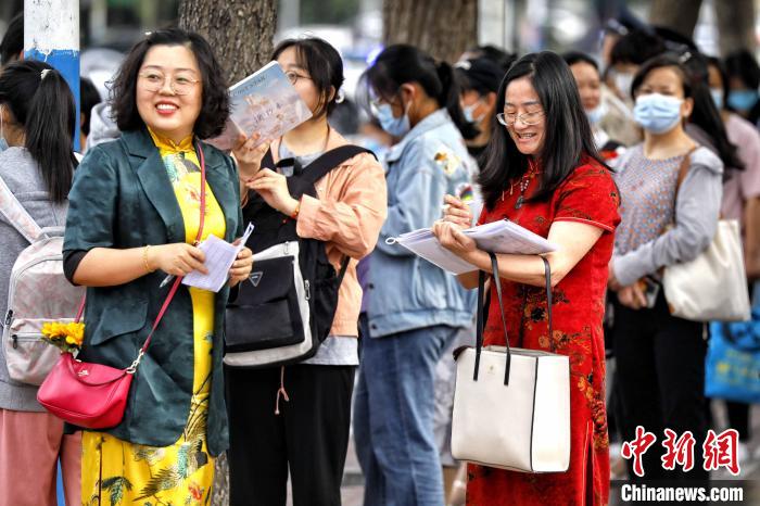 6月7日，高考首日，在泰安市泰山区的一处高考考点外，带队老师身穿旗袍为考生加油。　陈阳 　摄