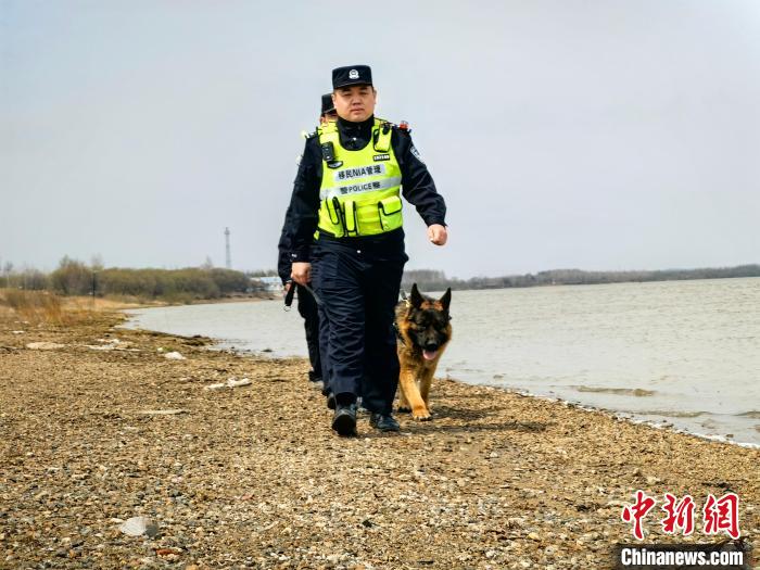 李金洋携警犬在边境巡逻。　张晓辉 摄