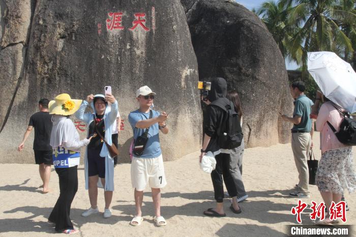 天涯海角游览区免门票首日，游客在天涯石旁拍照留念。　张月和 摄