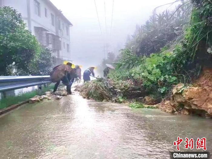 图为村干部对道路进行排险。　黄玉保 摄