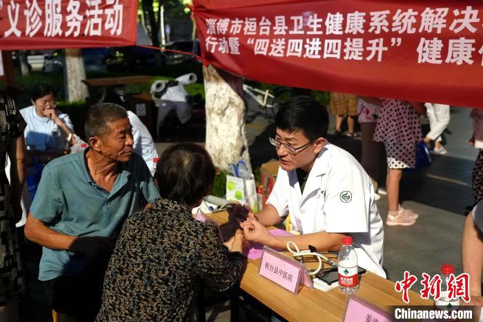 资料图：桓台县“中医药夜市”活动启动。中医专家利用晚上时间免费为民众开展中医把脉、问诊等服务。　张景富 摄