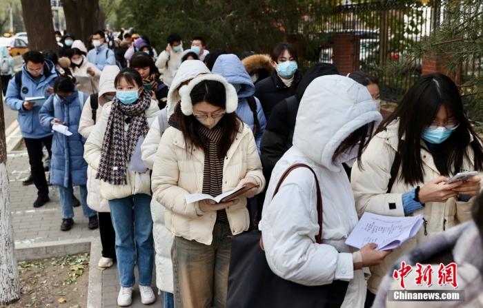 资料图：考生排队进入国考考点。中新社记者 易海菲 摄