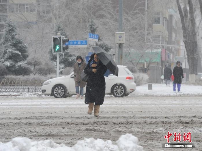 11月19日，吉林长春，市民冒雪出行。当日，吉林长春遭遇暴雪天气。
中新社记者 刘栋 摄