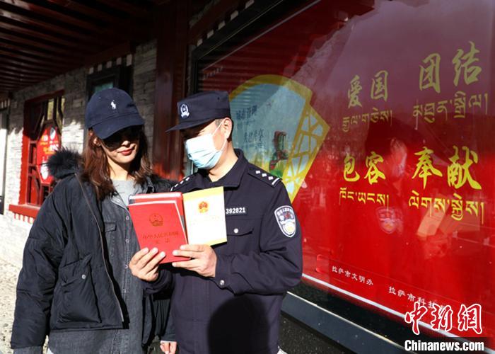 图为西藏出入境边防检查总站执法调查队民警向市民发放宣传资料和现场解答。　仁青旺堆 摄