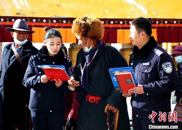 图为西藏出入境边防检查总站执法调查队民警向市民发放宣传资料和现场解答。　仁青旺堆 摄