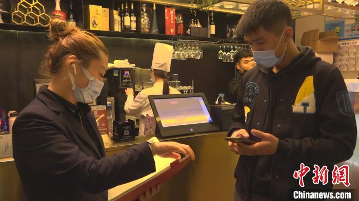 市民冯同光正在为家人预订年夜饭包房。　康玉湛 摄