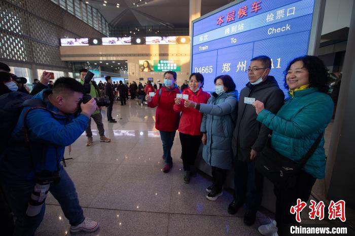 当日，搭乘首发列车的乘客早早来到候车室等候，特地取出纸质车票，进行合影留念。　韦亮 摄