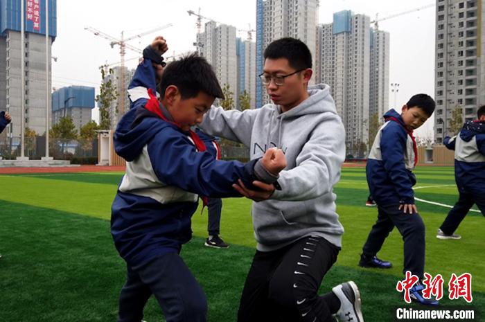 图为张晨卿对学生进行动作指导。　梅镱泷 摄