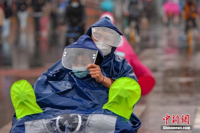 资料图：市民冒雨出行。
中新社记者 田雨昊 摄