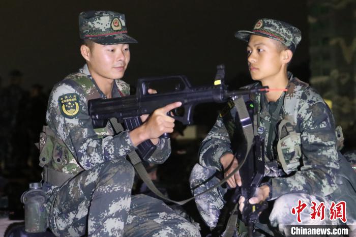 刘江(右)在向班长请教夜间射击技巧。陈国斌 供图