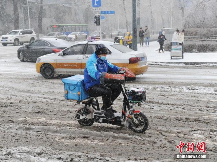 资料图：外卖小哥冒雪送餐。
中新社记者 刘栋 摄