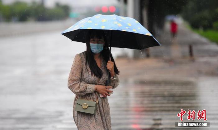 资料图：市民冒雨出行。
中新社记者 于海洋 摄