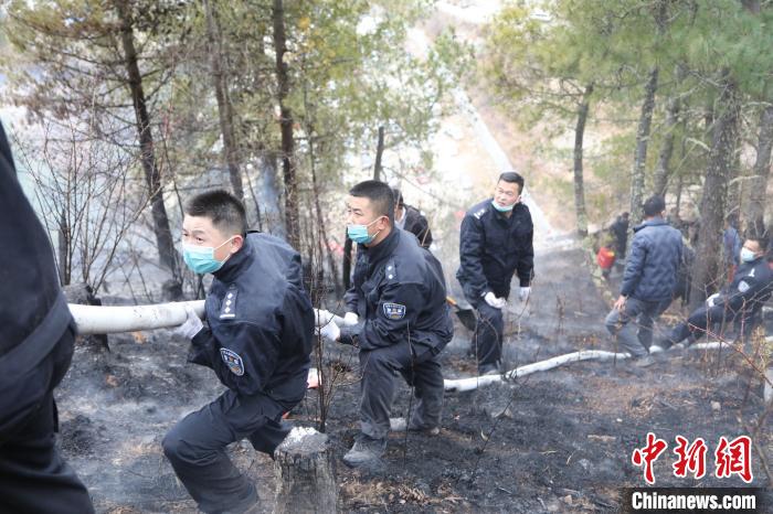 图为移民警察参与灭火。　张雨强 摄