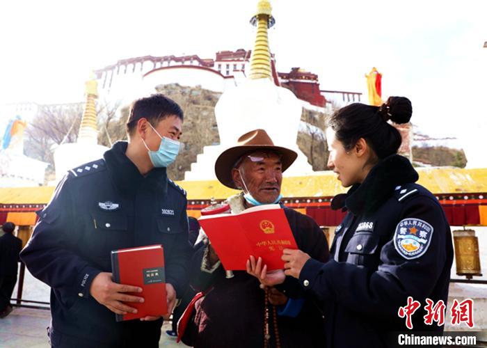 图为西藏出入境边防检查总站执法调查队民警向市民发放宣传资料和现场解答。　仁青旺堆 摄