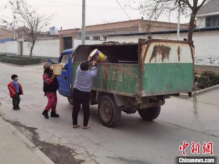 居民听到音乐，自觉出门投放垃圾。　胡健 摄