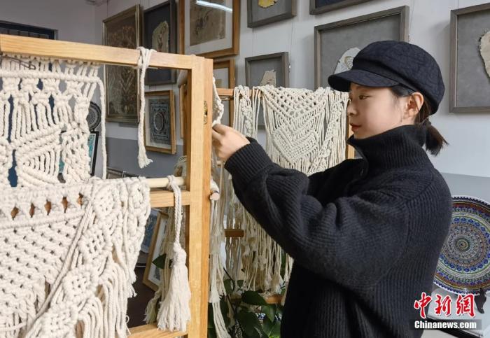 图为学生制作手工壁饰。