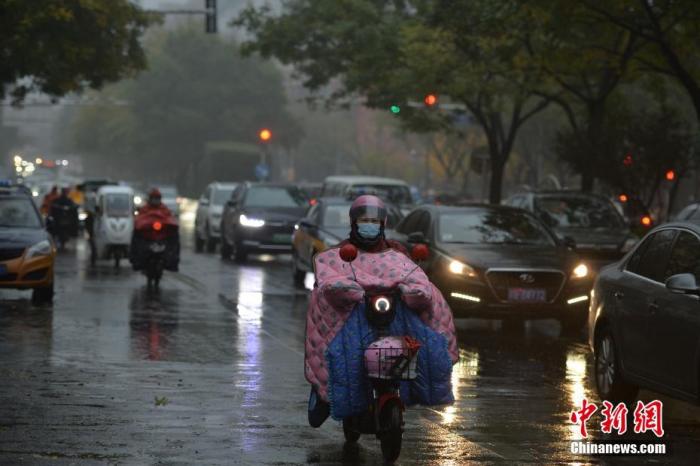 资料图：市民冒雨出行。
中新社记者 田雨昊 摄