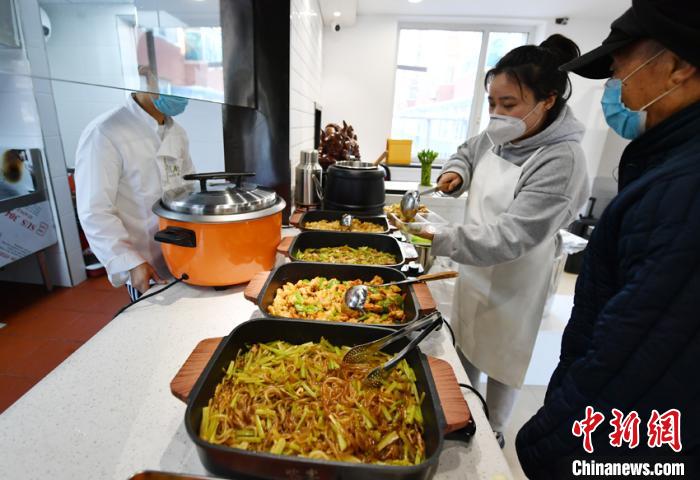 工作人员为老人打饭 张瑶 摄