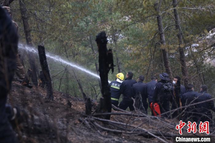 图为移民警察协助驻地消防员灭火。　张雨强 摄