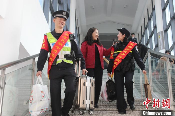 图为民警华炳杰(左一)为乘客拎行李箱。(资料图) 余艳芬 摄