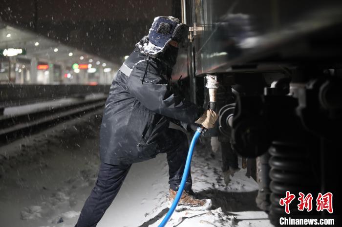 上水员冒雪给列车进行上水作业。孙晓晨 供图